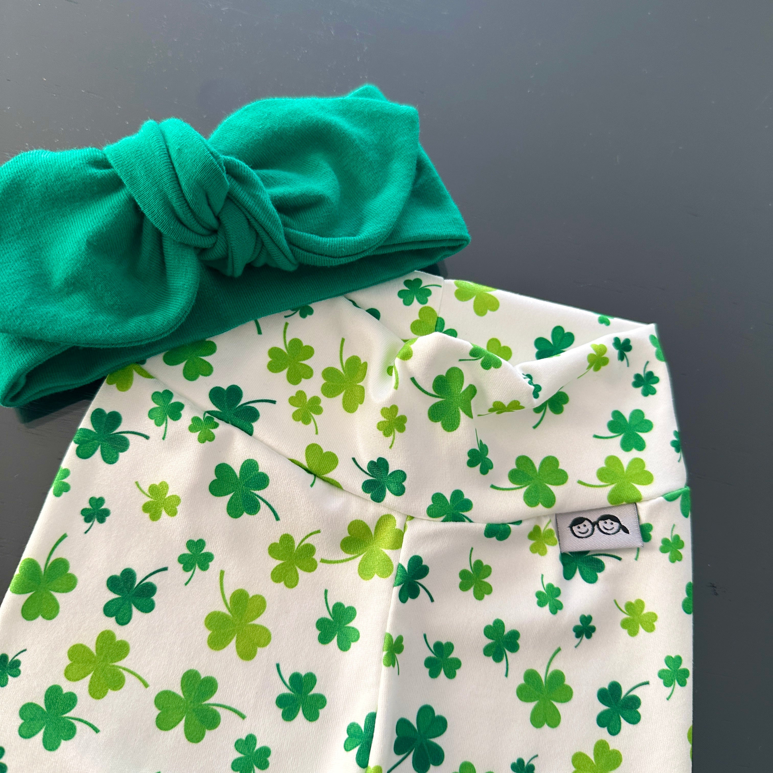 Festive green shamrock print leggings paired with a matching knotted headband, perfect for St. Patrick&