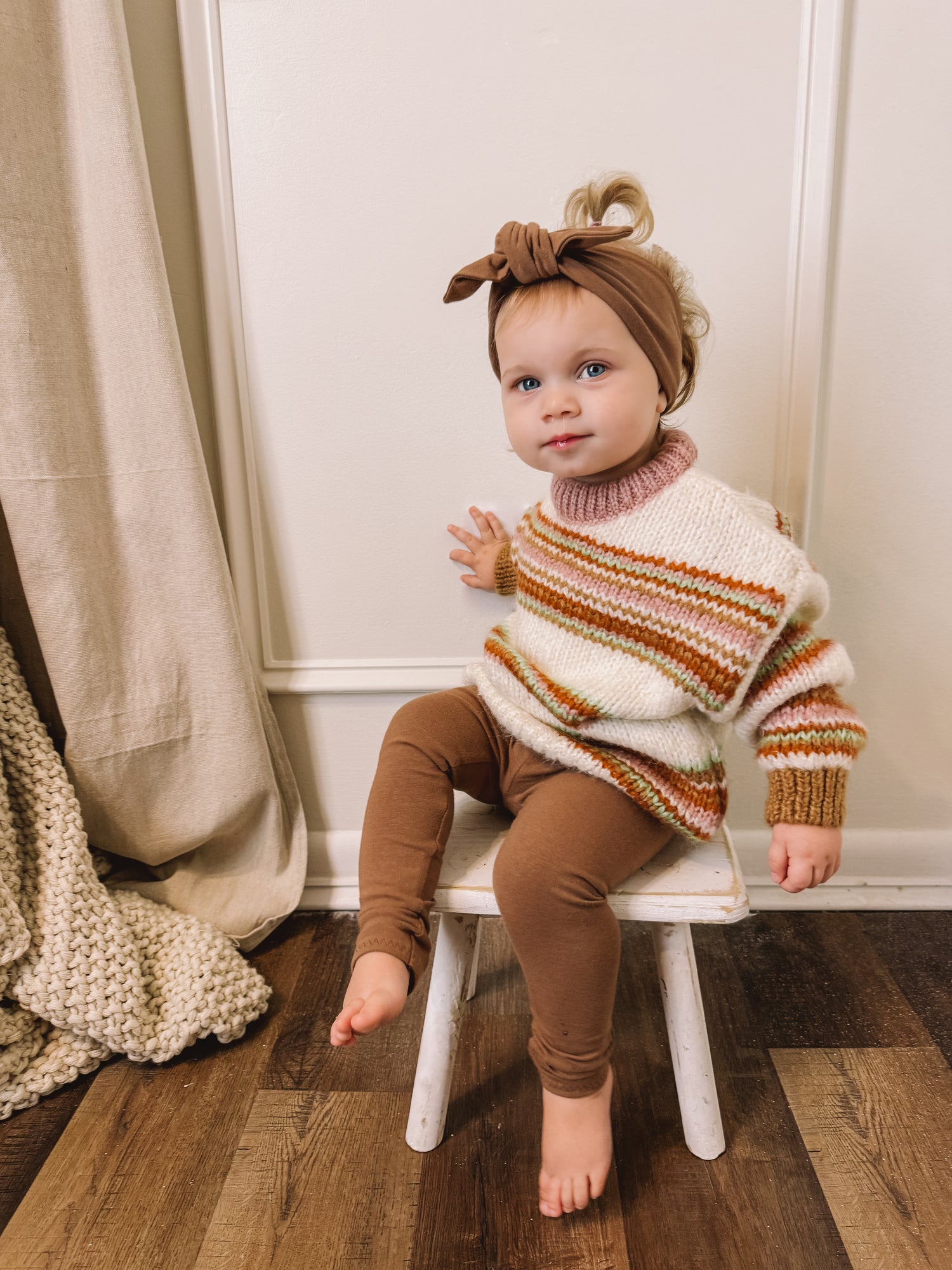 Toddler Girl in Mocha Leggings Sitting on Chair