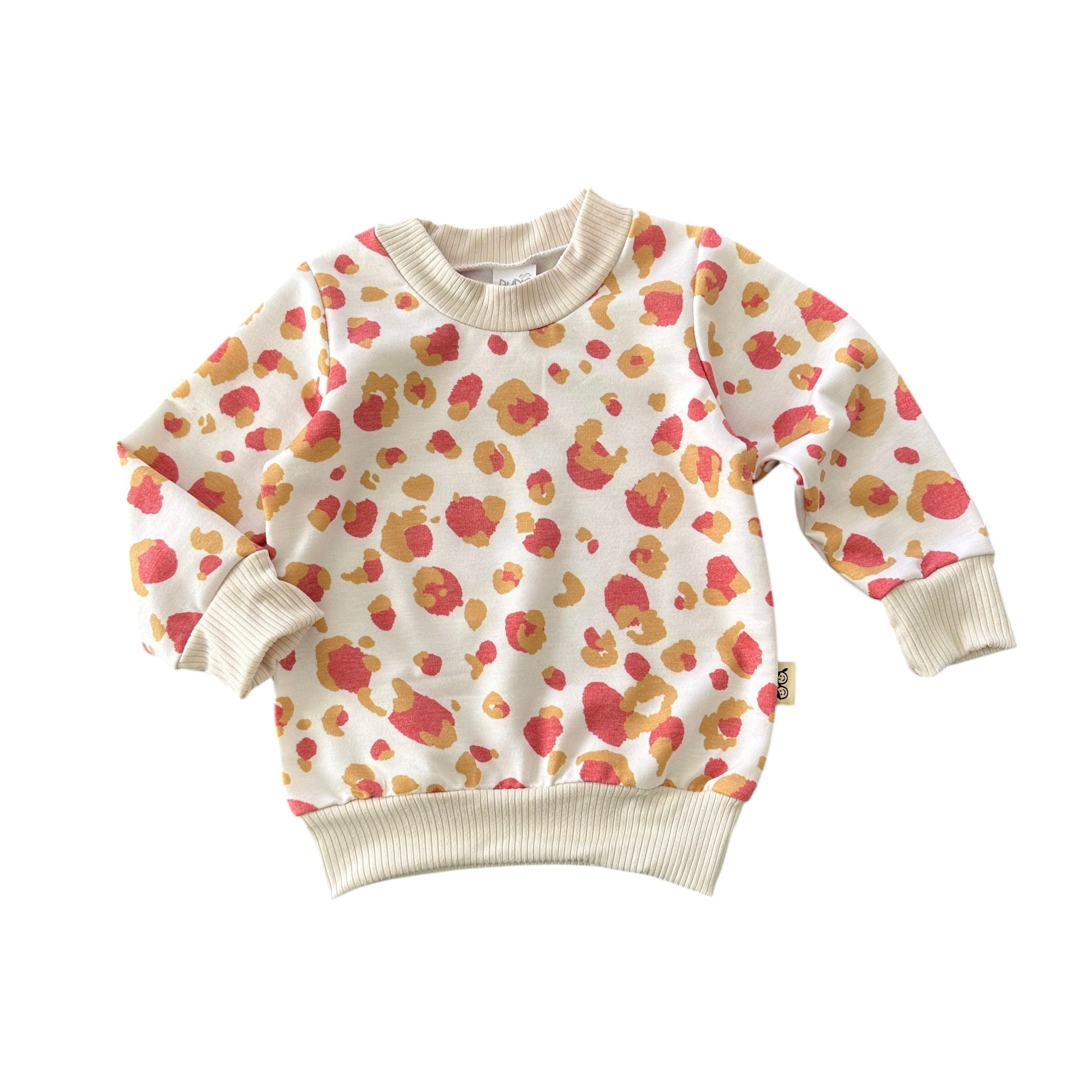 Cream baby sweatshirt with coral and mustard leopard print and beige ribbed cuffs, cozy handmade toddler top.