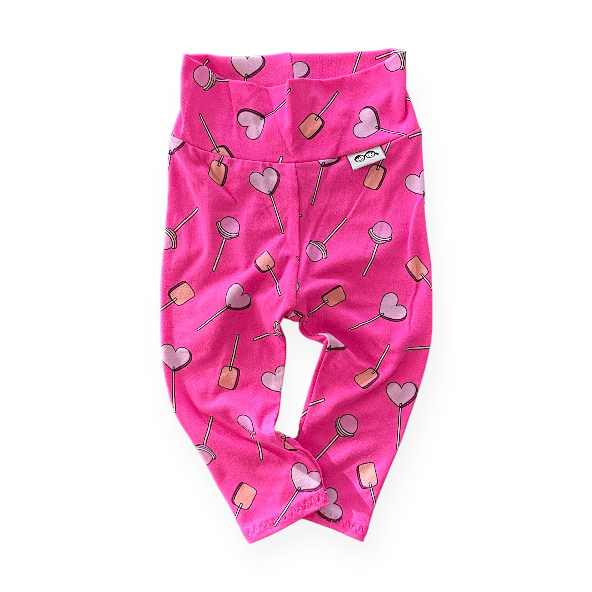 Handmade baby and toddler leggings featuring a playful pink lollipop and heart pattern. Designed for comfort and flexibility, these leggings are perfect for everyday wear or special occasions. Available in sizes preemie to 4T.