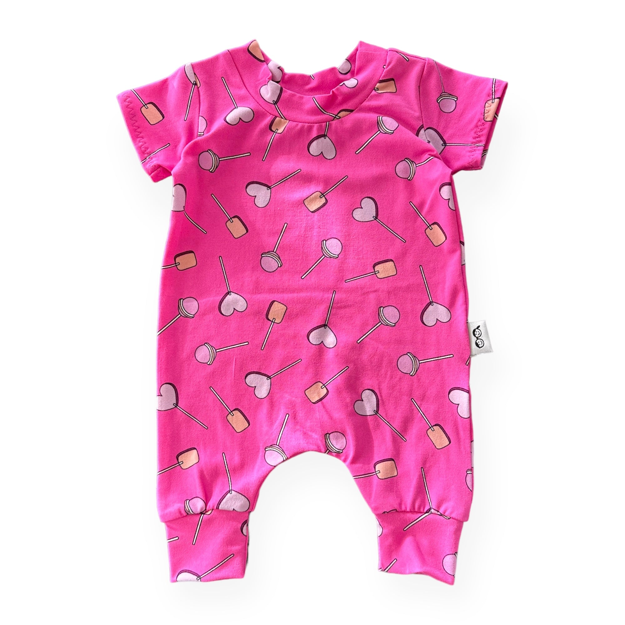 This adorable handmade romper is perfect for your little sweetie! Featuring a fun lollipop and heart design on a bright pink background, it’s as comfy as it is cute. Made for sizes preemie to 4T.