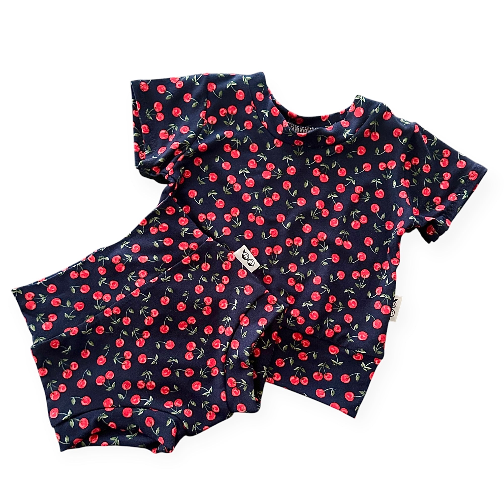 Midnight Cherries baby outfit set – handmade baby summer clothing featuring a cherry print, including a short sleeve top and matching bummies. Soft, blend cotton babywear for stylish infants.