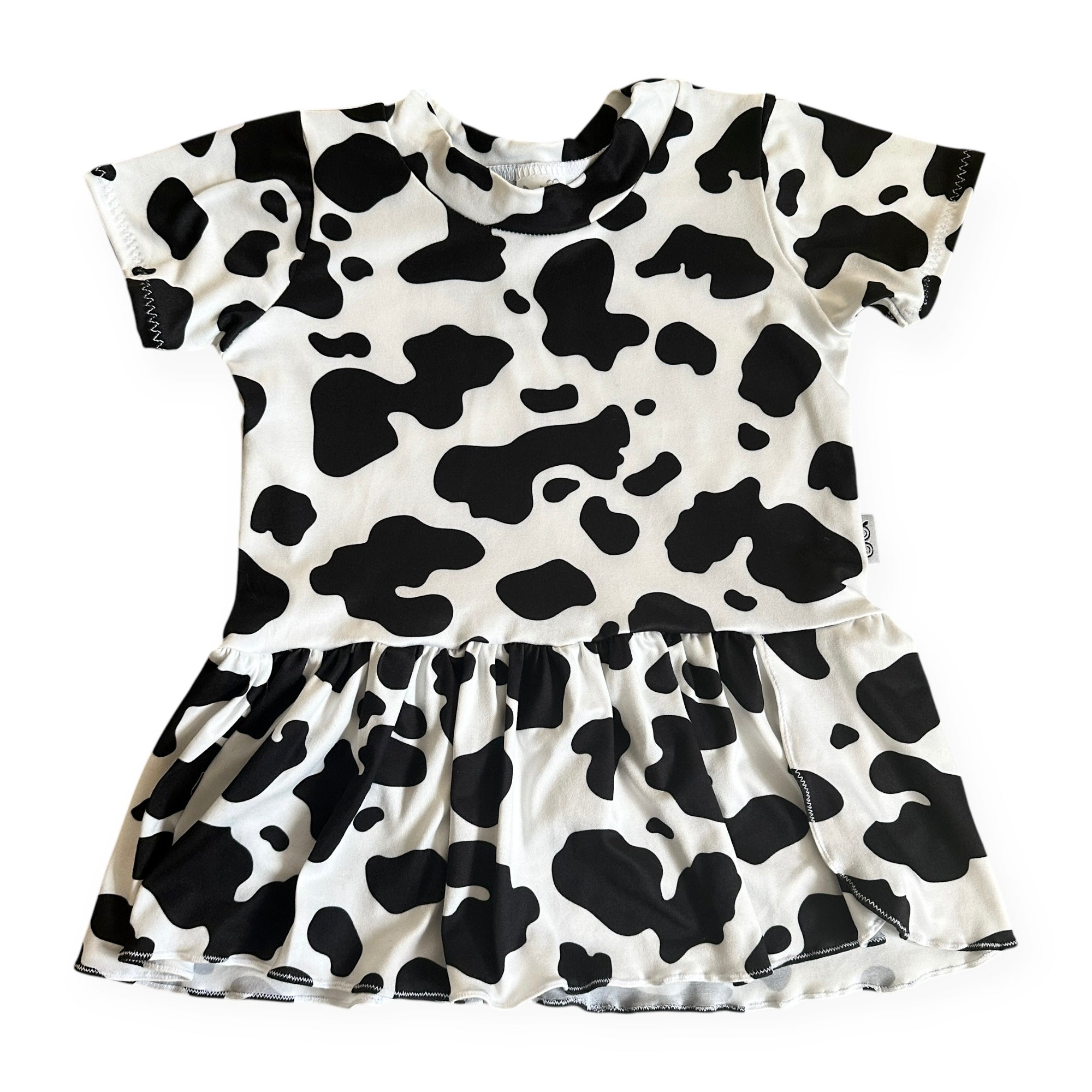 Girls cow print dress in black and white with short sleeves and gathered skirt, handmade toddler outfit perfect for birthdays or farm-themed parties.