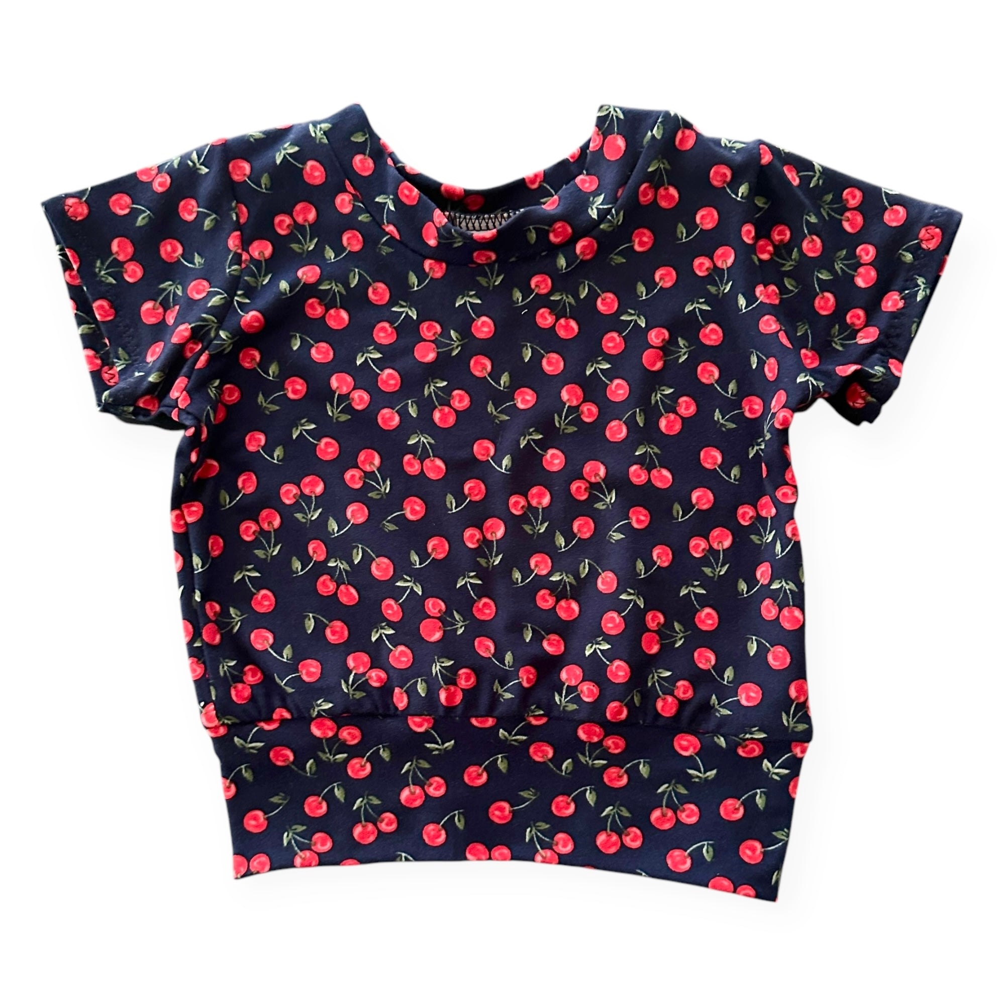 Midnight Cherries Baby T-Shirt – a short-sleeve handmade pullover with a cherry print on a navy background. Soft, stretchy, and perfect for stylish baby and toddler outfits.
