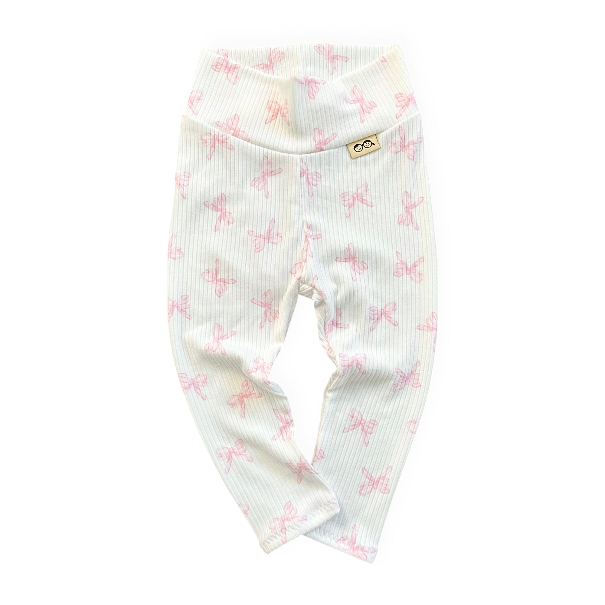 White baby leggings with pink bow pattern on a white background
