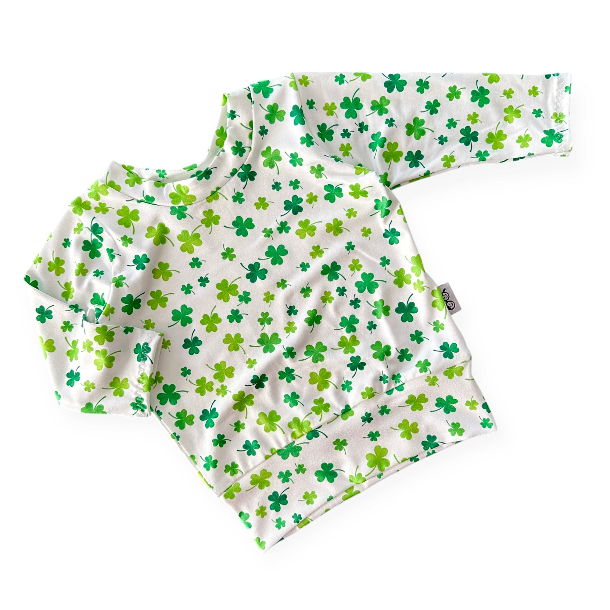 Handmade white lounge top with green shamrock print for babies and toddlers. Perfect for St. Patrick&