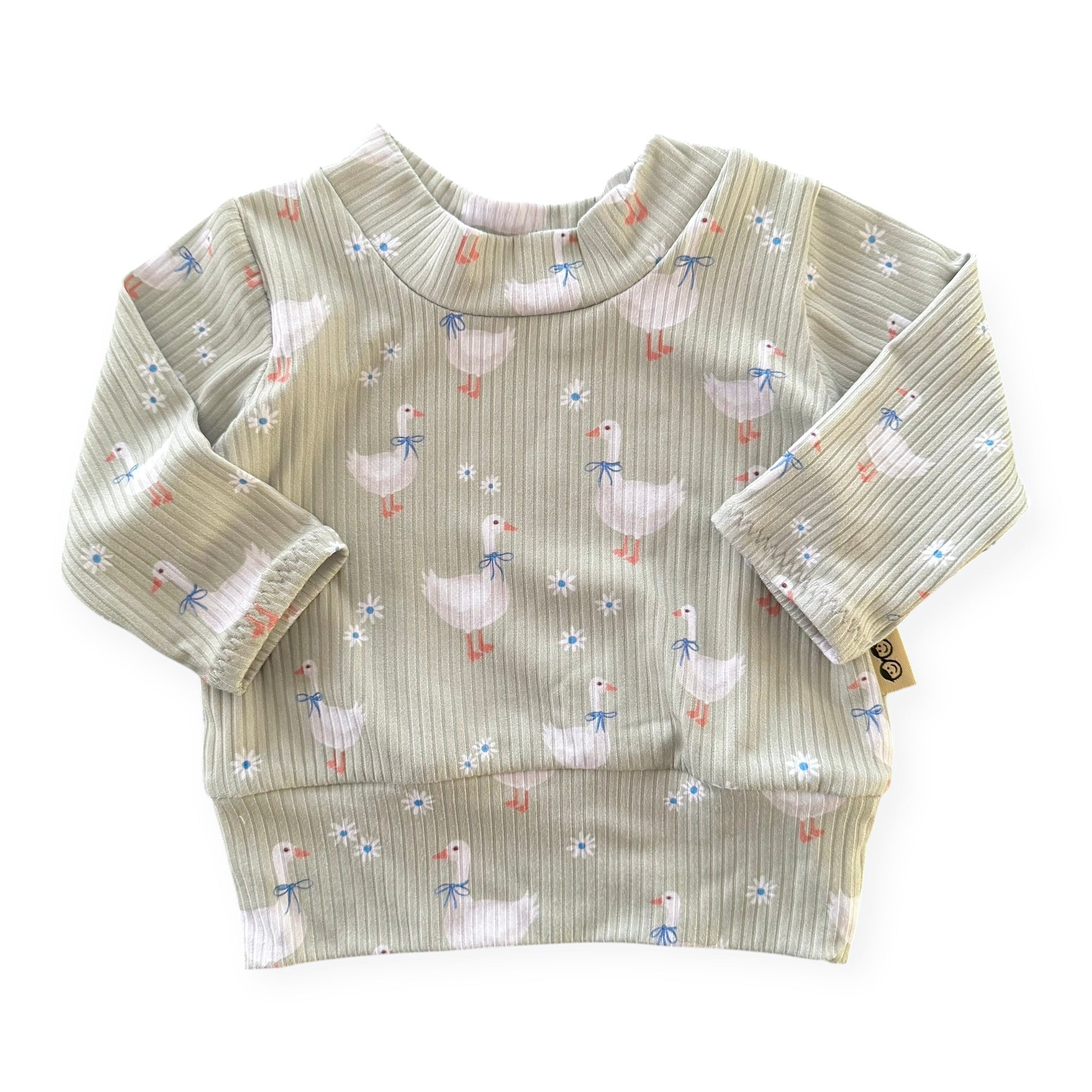 Baby shirt with duck pattern on a white background