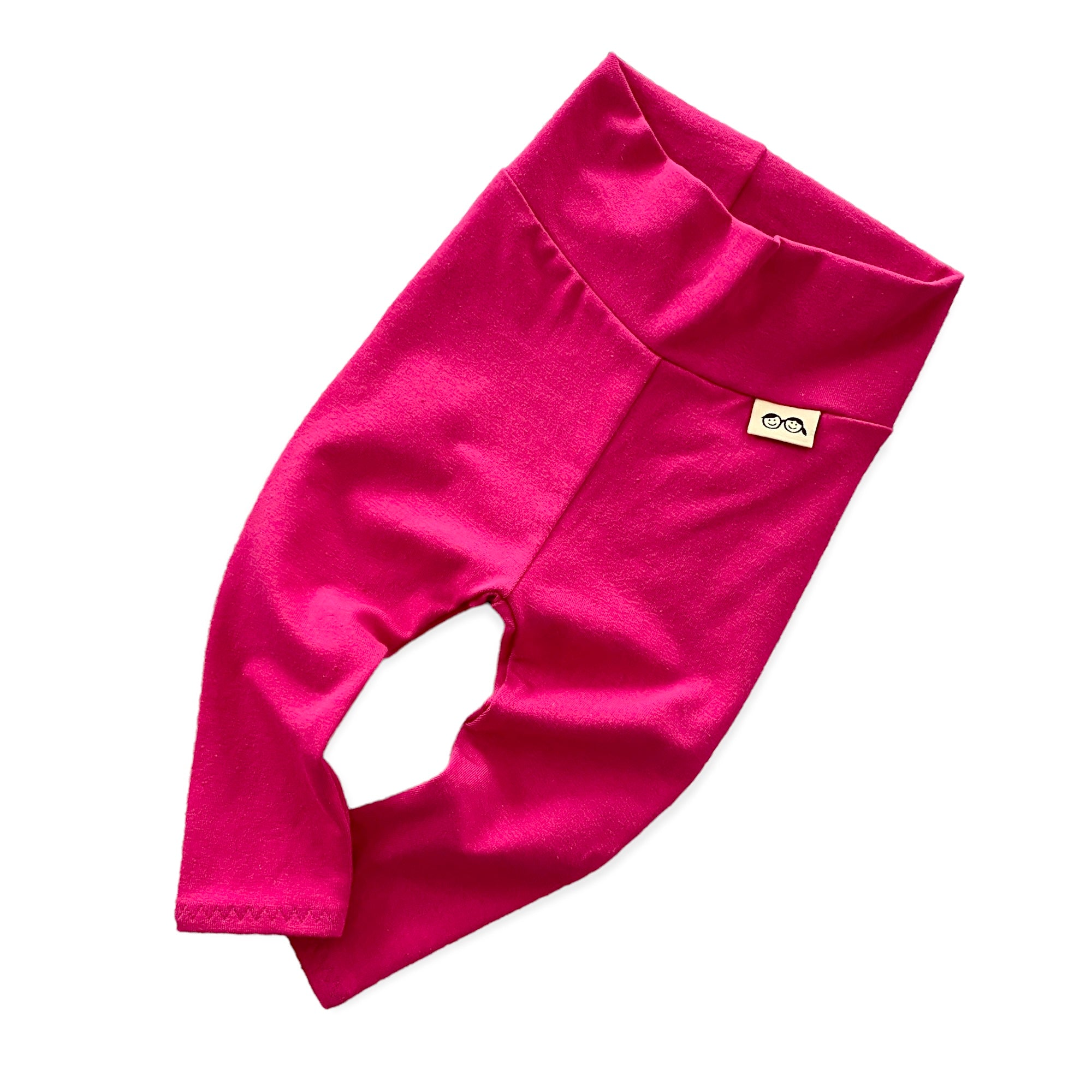 Handmade hot pink baby leggings with a fold-over waistband, displayed flat on a white background. Soft and stretchy for a perfect fit, these gender-neutral baby pants are great for layering with onesies, sweaters, and tees. Available in sizes preemie to 4T.