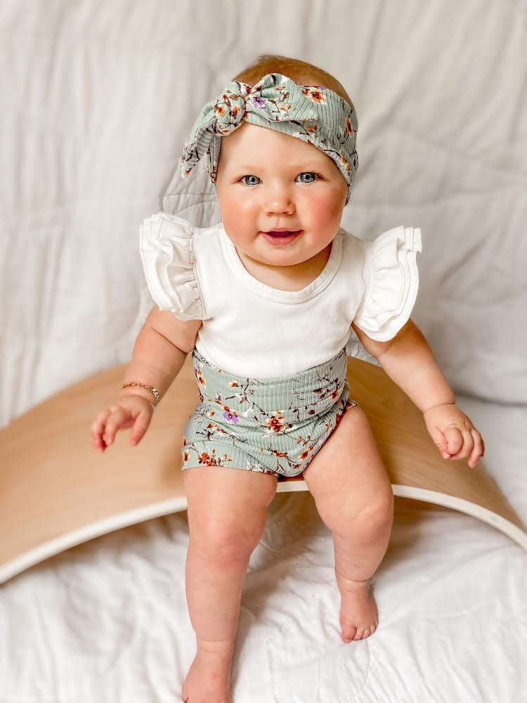 Baby Girl Wearing Dried Floral on Sage Ribbed Bummies