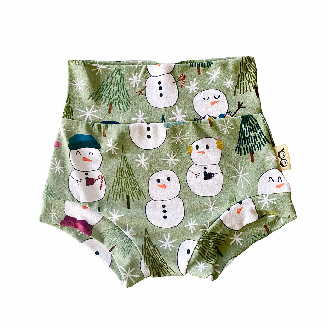 Snowman Print Bummies featuring a festive design of snowmen and winter trees on a soft green background. Handmade high-waisted diaper covers for babies and toddlers, perfect for holiday celebrations and seasonal wear.