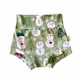 Snowman Print Bummies featuring a festive design of snowmen and winter trees on a soft green background. Handmade high-waisted diaper covers for babies and toddlers, perfect for holiday celebrations and seasonal wear.