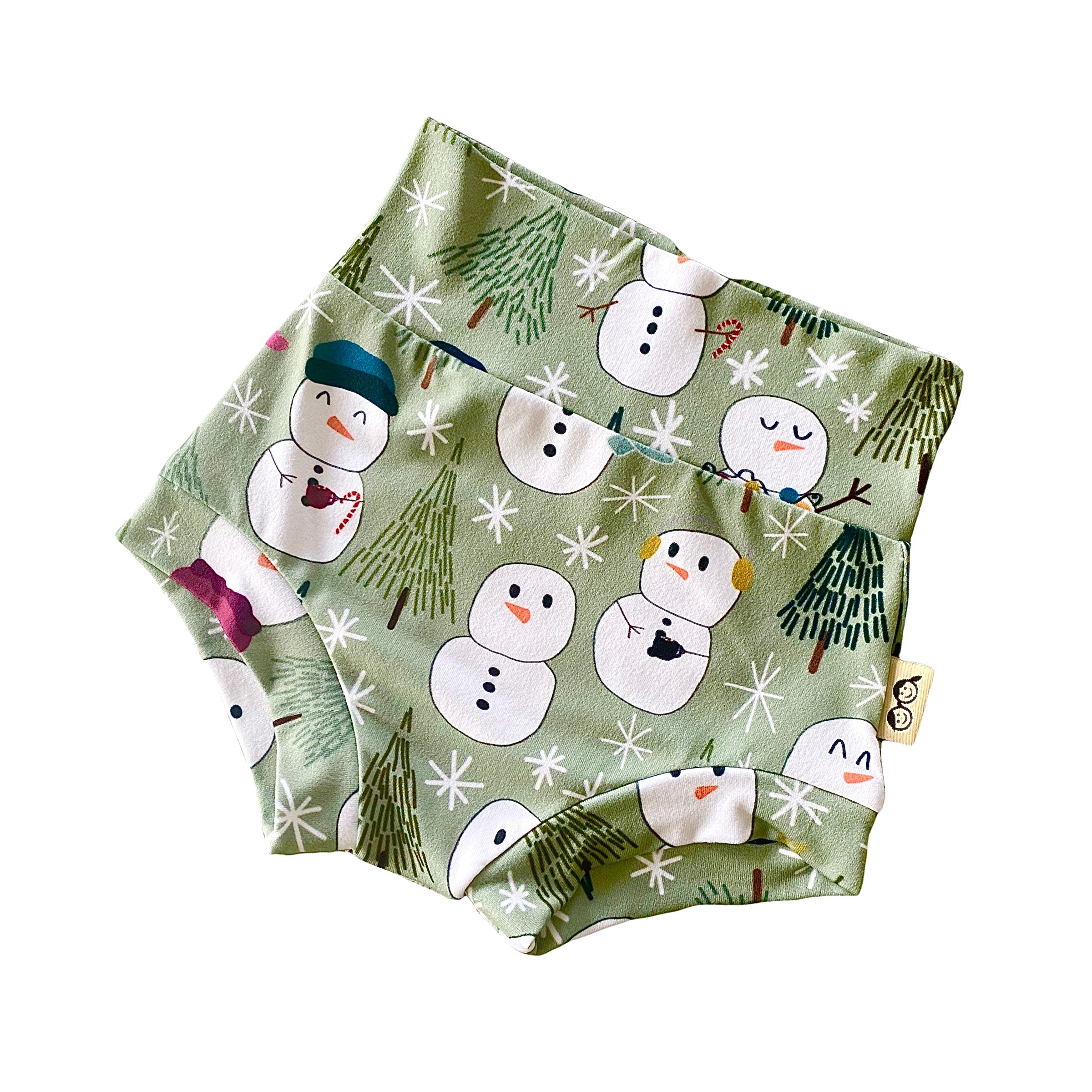 Snowman Print Bummies featuring a festive design of snowmen and winter trees on a soft green background. Handmade high-waisted diaper covers for babies and toddlers, perfect for holiday celebrations and seasonal wear.