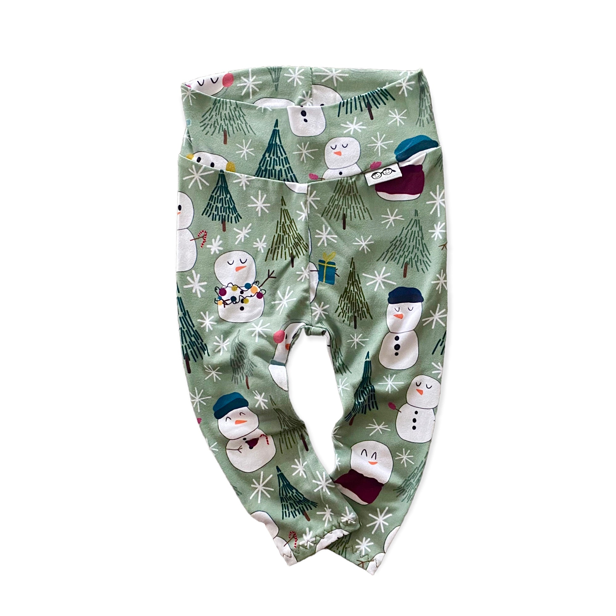 Snowman Print Lounge Set featuring a long-sleeve pullover and matching leggings with a playful snowman and winter tree design on a soft green background. Handmade for babies and toddlers, perfect for holiday celebrations and seasonal wear.