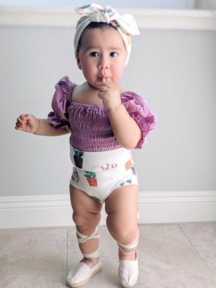 White baby bummies with cute succulent designs, perfect for casual and stylish looks.