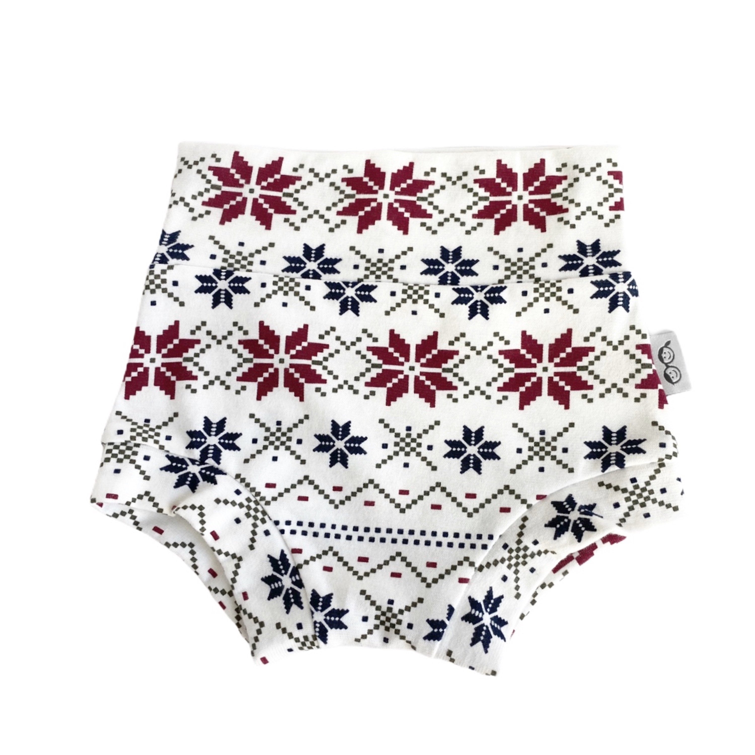 Handmade baby bummies with festive Nordic snowflake pattern in red, navy, and cream. Perfect diaper covers for holiday and winter outfits.
