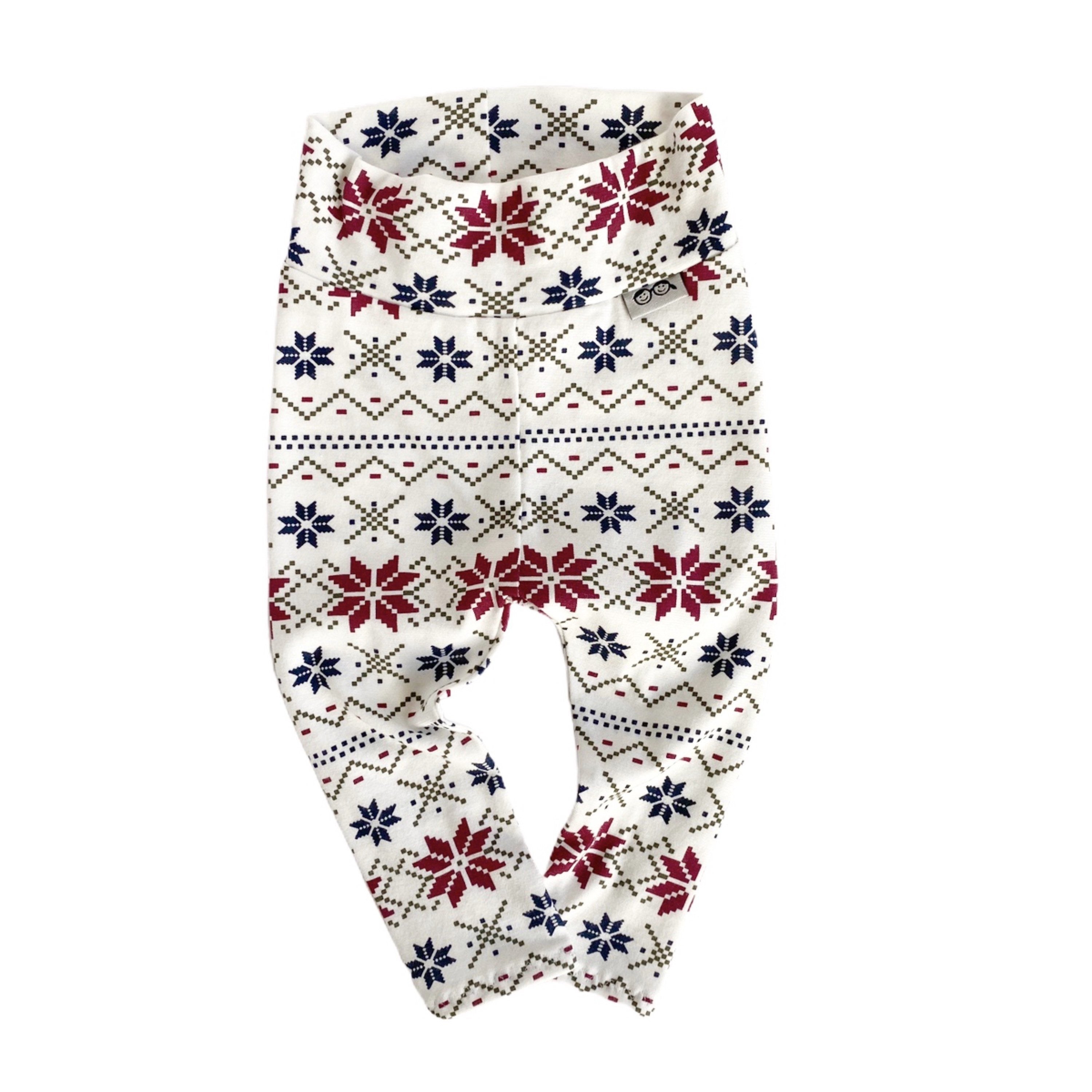 Handmade baby leggings with festive Nordic snowflake pattern in red, navy, and cream. Perfect for cozy winter outfits and holiday photos.