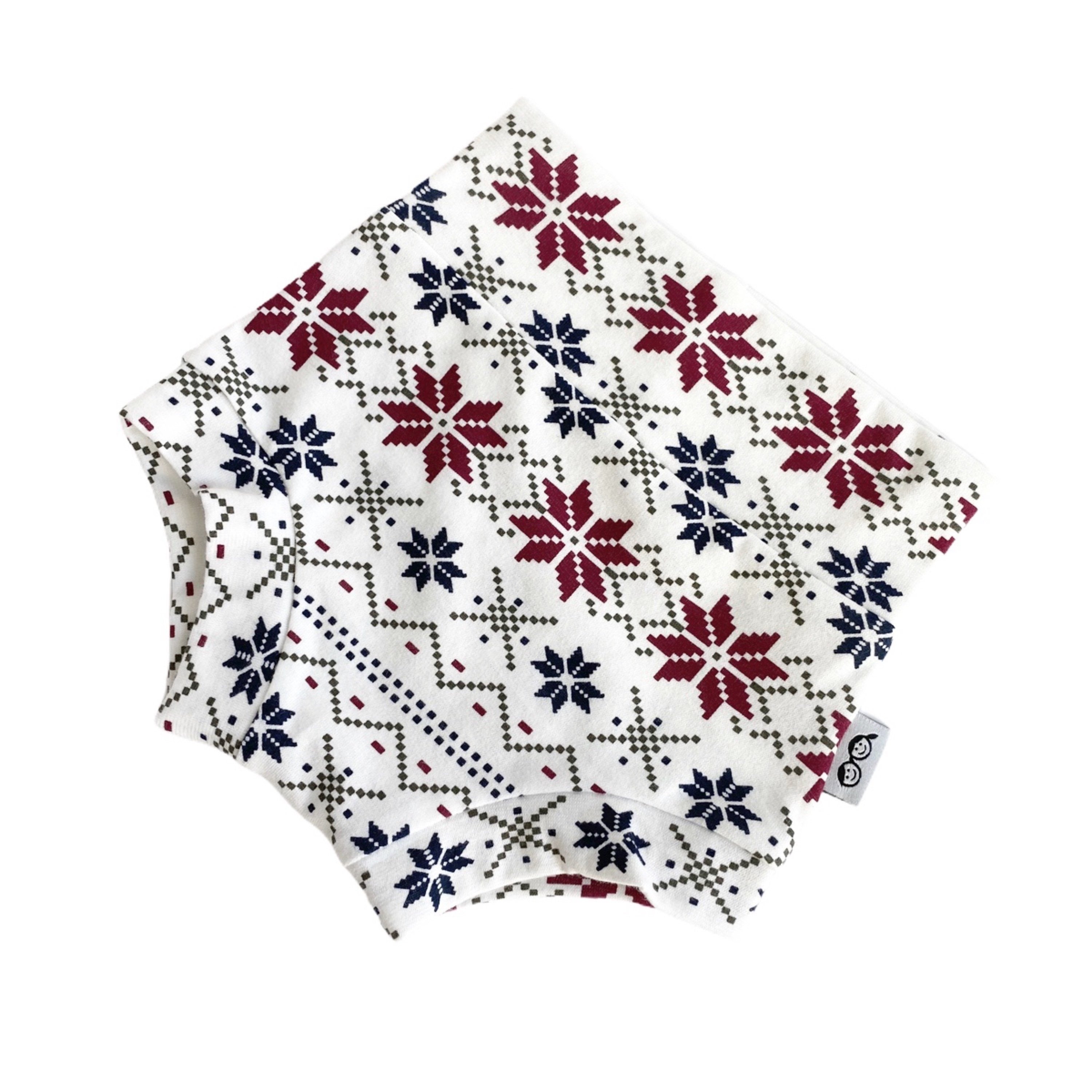 Handmade baby bummies with festive Nordic snowflake pattern in red, navy, and cream. Perfect diaper covers for holiday and winter outfits.