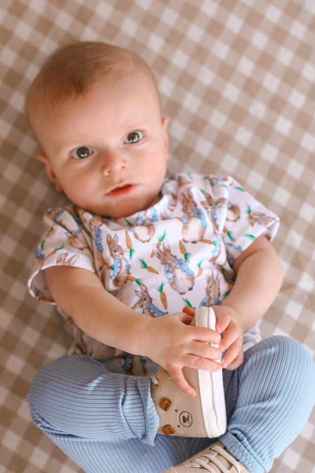 Cozy baby lounge set featuring a vintage rabbit print short-sleeve top and matching blue ribbed leggings. A comfortable, stylish, and breathable outfit for babies and toddlers. Ideal for casual wear, Easter outfits, and gender-neutral baby clothing collections.