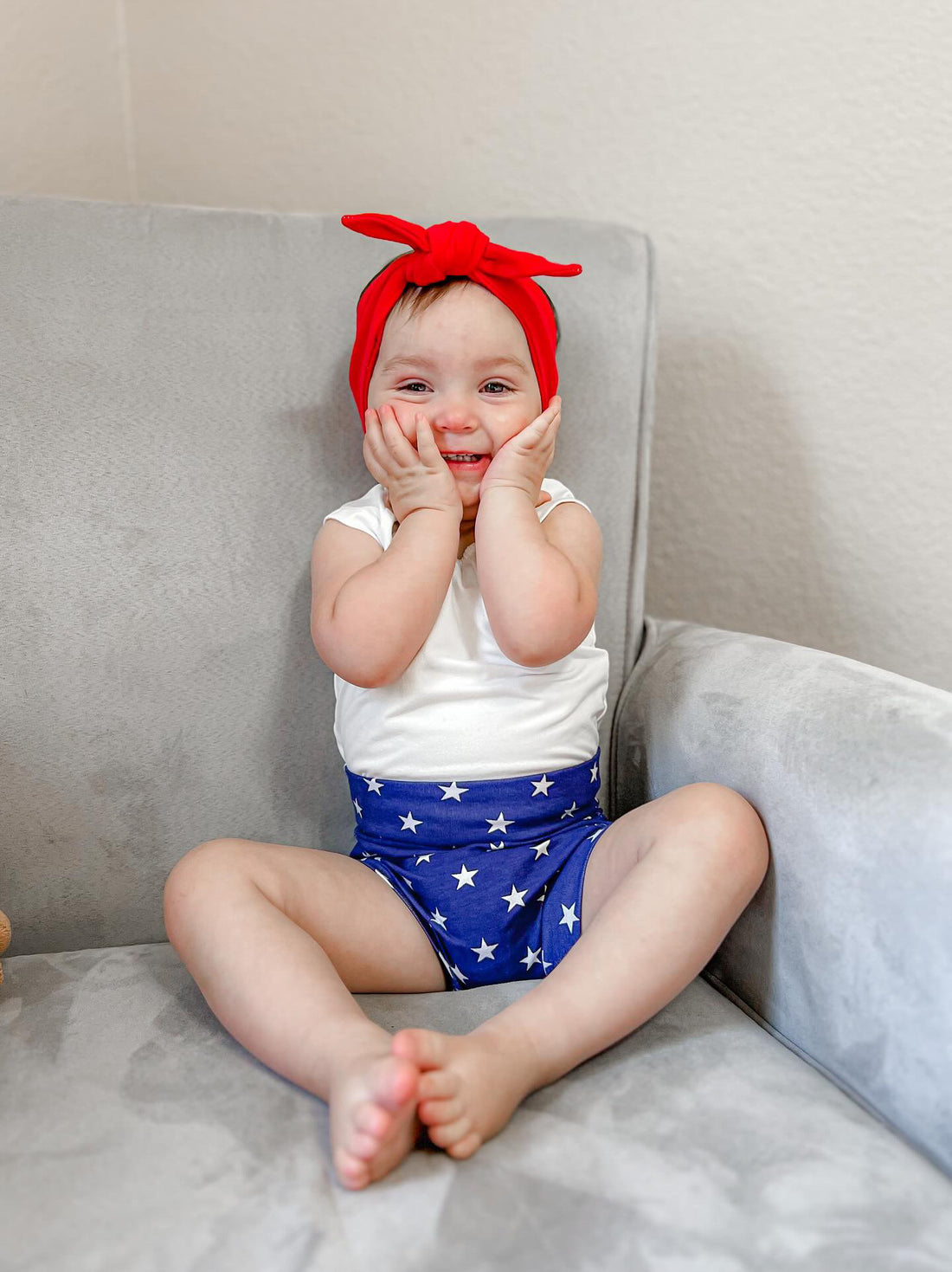 baby girl in Navy Stars Bummies with Red Headband