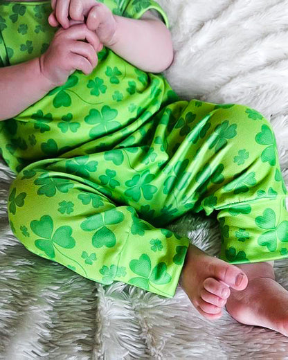 Detailed close-up of romper fabric on baby’s knee – High-quality four-leaf clover print baby romper. Soft, stretchy fabric for all-day comfort and pinch-proof protection.