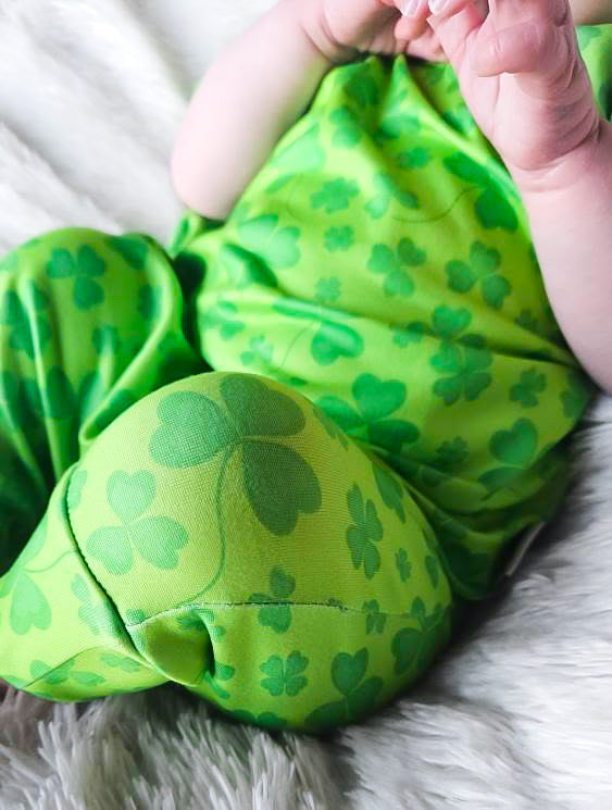 Close-up of green clover baby romper fabric – St. Patrick’s Day baby romper with soft, breathable shamrock print fabric. Perfect festive outfit for newborns, infants, and toddlers.