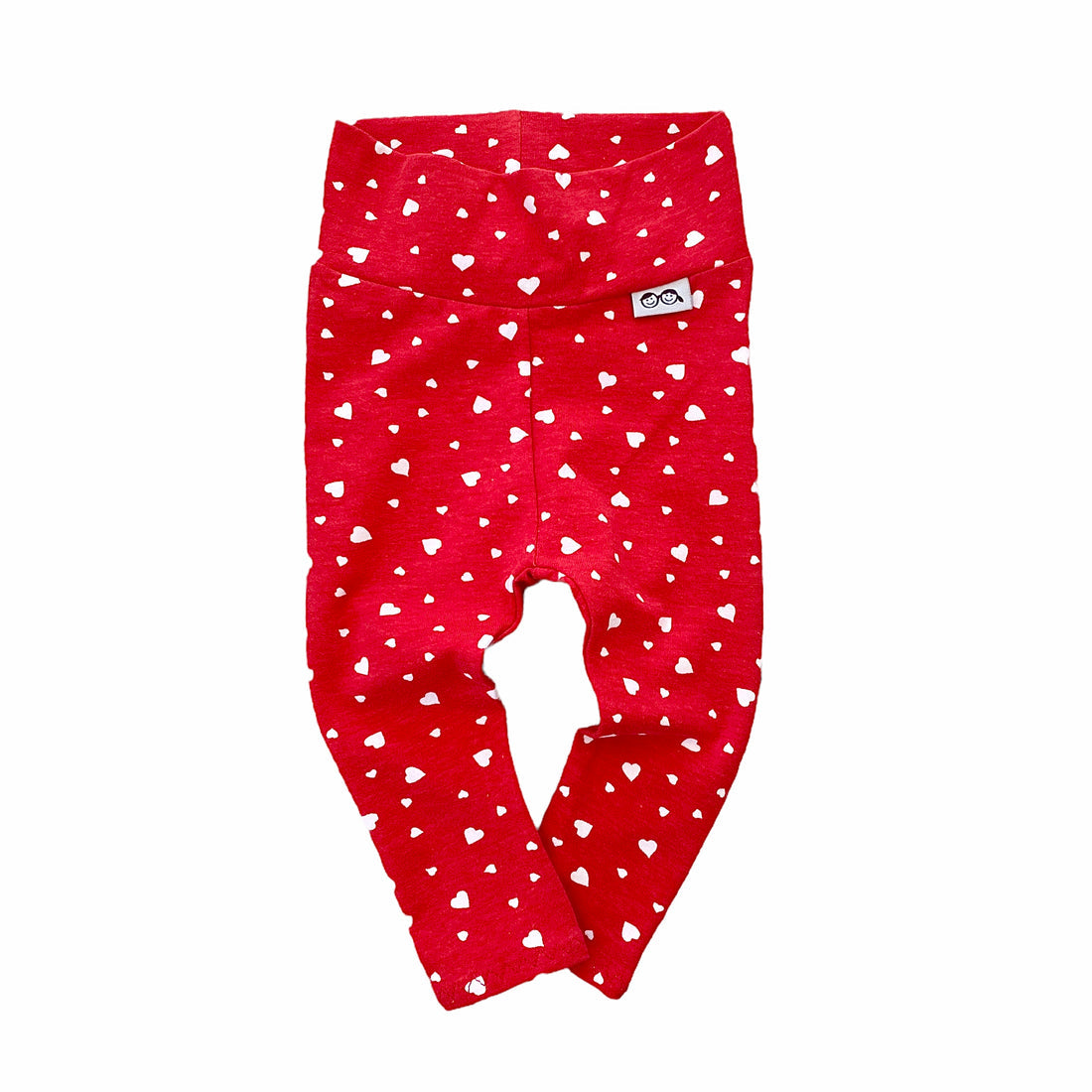 Red high-waisted baby leggings featuring an all-over white heart print. Comfortable and festive, ideal for mixing and matching.