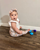 Baby wearing matching leggings and headband in cozy camping print.