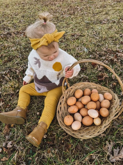 Little Girl in Mustard Ribbed Top Knot Headband, harvesting eggs