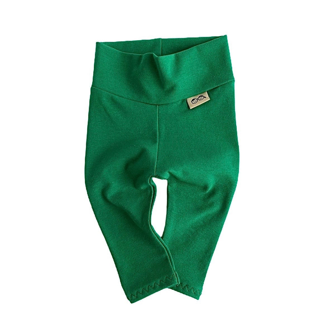 Handmade green baby leggings with a fold-over waistband, displayed on a white background. Soft, stretchy, and perfect for newborns, infants, and toddlers. A stylish and comfortable option for St. Patrick’s Day outfits, festive wear, or everyday layering. Available in sizes preemie to 4T