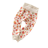 Coral and mustard leopard print baby harem pants with beige stretch waistband and cuffs, soft handmade baby bottoms.