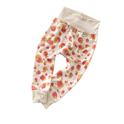 Coral and mustard leopard print baby harem pants with beige stretch waistband and cuffs, soft handmade baby bottoms.