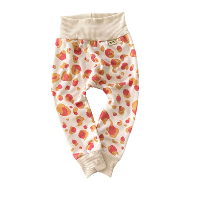 Neutral cream harem pants with coral and mustard leopard spots, belly-friendly waistband, unisex handmade baby pants.
