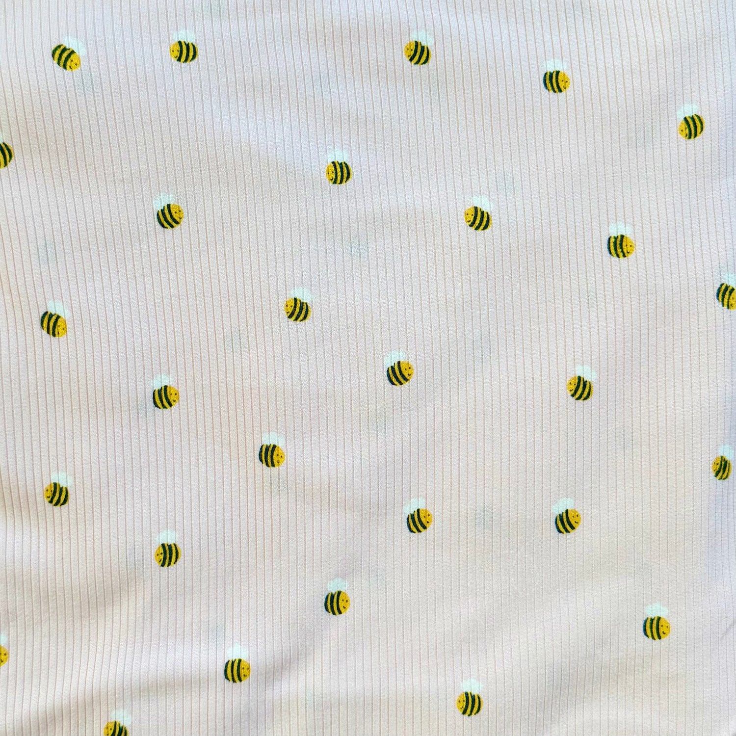 Pattern of small bees on a textured beige background