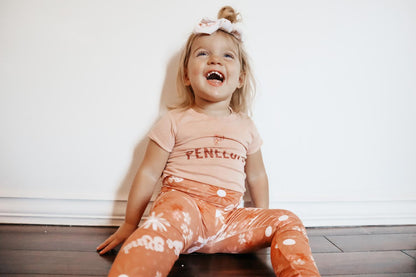 Child wearing a pink shirt with &