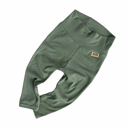 Flat-lay of soft ribbed green baby pants, featuring a wide waistband for comfort and flexibility.