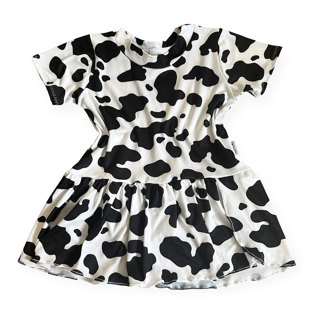 Girls cow print dress in black and white with short sleeves and gathered skirt, handmade toddler outfit perfect for birthdays or farm-themed parties.