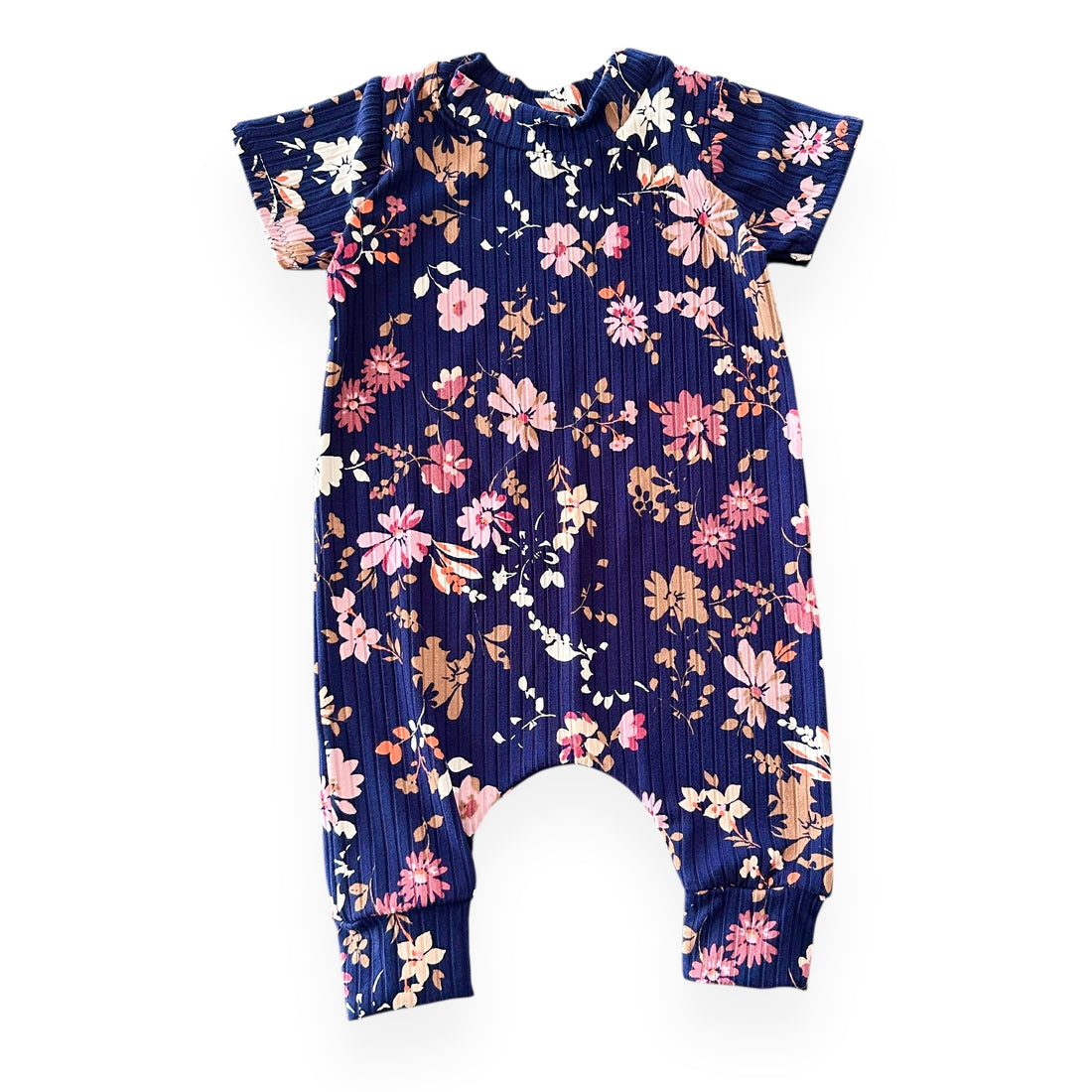 Navy ribbed baby romper with pink, mauve, and tan floral print – short sleeves and cuffed legs, laid flat.
