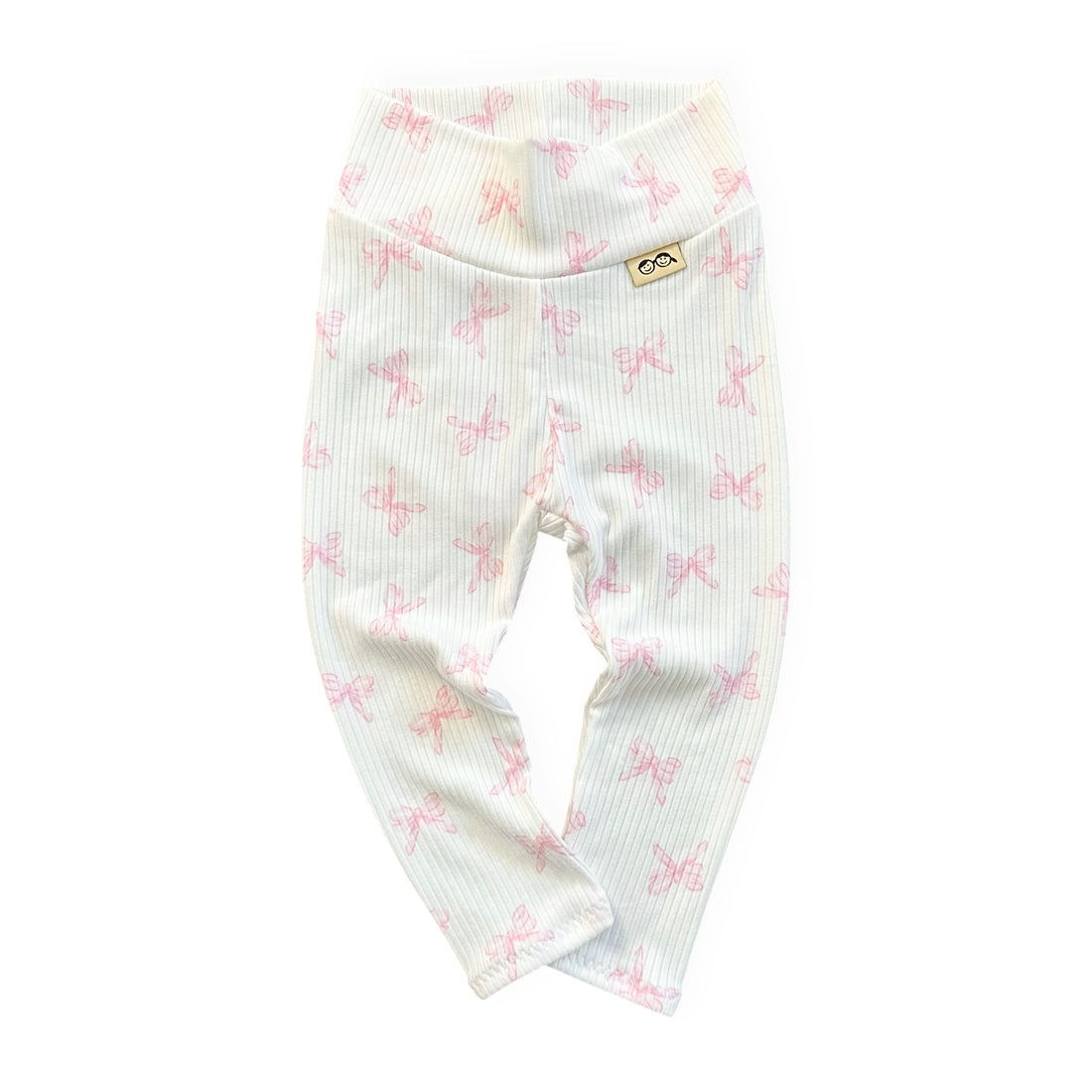 White baby leggings with pink bow pattern on a white background