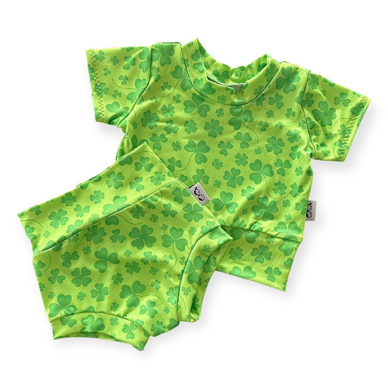 Green shamrock baby outfit set, including a short-sleeve t-shirt and matching high-waisted bummies. Perfect for St. Patrick’s Day celebrations or festive everyday wear. Handmade with soft, stretchy fabric for ultimate comfort and style for newborns, infants, and toddlers.