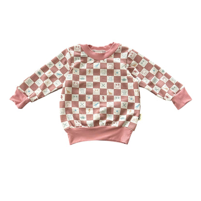 Angled view of mauve checker smiley icons baby sweatshirt.