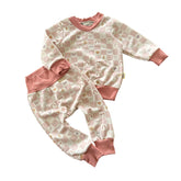 Baby lounge set in blush pink checker print with smiley faces and icons, front view top and pants.