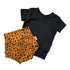 Black short-sleeve top and tan bummies with black spots on a white background
