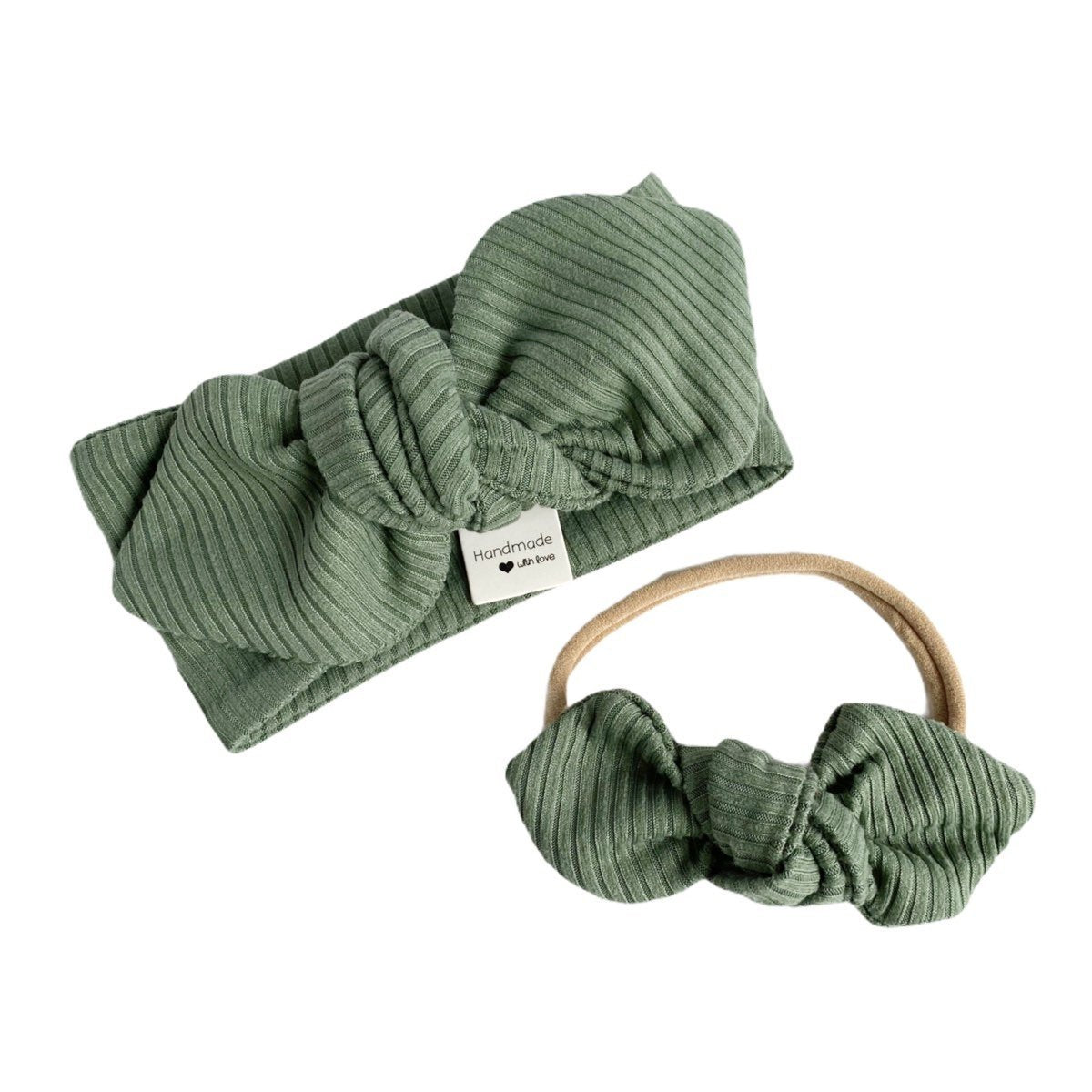 Flat-lay of a ribbed green bow headband and matching nylon baby bow, perfect for accessorizing little ones.